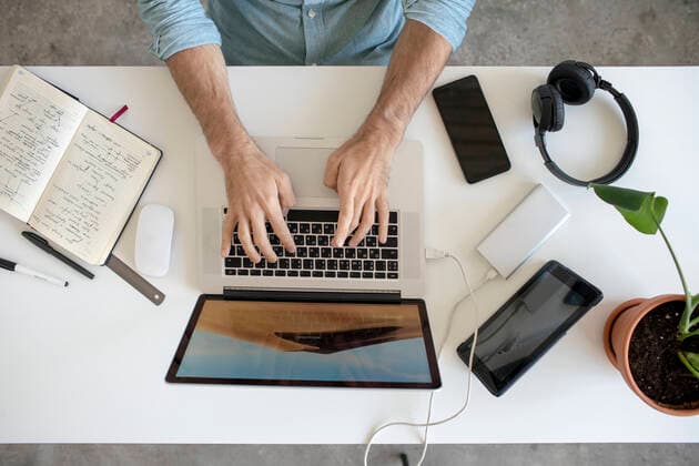 Top view of man using laptop at desk in office model released Symbolfoto property released  VPIF01784