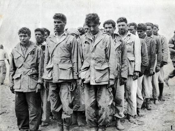 GUERRE D ALGERIE Groupe de prisonniers algeriens encadres par des militaires francais. Photographie anonyme vers 1958 pour la propagande francaise. Credit : Collection IM Kharbine-Tapabor. *** ALGERIAN WAR Group of Algerian prisoners framed by French soldiers Anonymous photograph around 1958 for French propaganda Credit Collection IM Kharbine Tapabor  KH202429