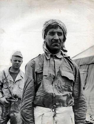 GUERRE D ALGERIE Prisonnier algerien garde par un militaire francais. Photographie anonyme vers 1958 pour la propagande francaise. Credit : Collection IM Kharbine-Tapabor. *** ALGERIAN WAR Algerian prisoner guarded by a French military officer Anonymous photograph around 1958 for French propaganda Credit Collection IM Kharbine Tapabor  KH202433