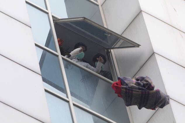 NOIDA, INDIA - JANUARY 9: People on a higher floor fling objects out the window during a fire incident in the basement of ESIC Hospital at Sector 24 on January 9, 2020 in Noida, India. (Photo by Sunil Ghosh Hindustan Times) Fire At Noida ESIC Hospital