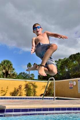 A boy jumps into a hotel pool on vacation in Florida Florida, USA CR_BABE191030-215789-01