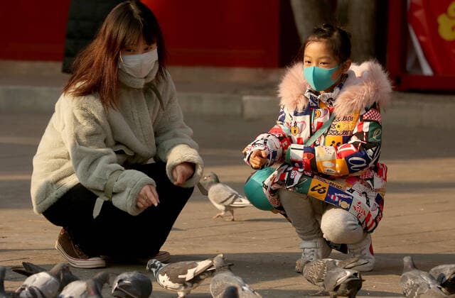 Chinese wear protective respiratory masks in Beijing on Wednesday, January 22, 2020. Health authorities in China reported the country s sixth death from a new type of coronavirus, as the country braces for the Lunar New Year travel boom amid concerns over a possible outbreak similar to that of the SARS virus in the early 2000s.  PEK2020012207 STEPHENxSHAVER