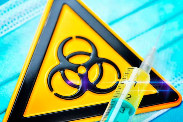 Syringe and biohazard shield on a mouthguard, symbol photo Coronavirus ** NUR FUER REDAKTIONELLE ZWECKE ** EDITORIAL USE ONLY **
