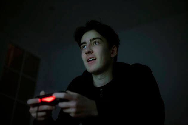 Teenage boy playing video game with console in the dark model released Symbolfoto property released  AJOF00077