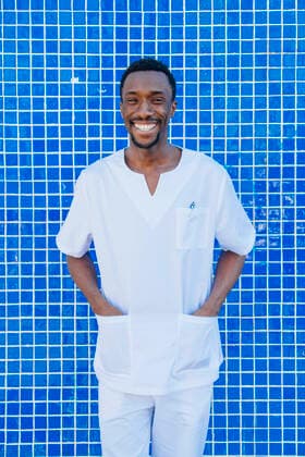 Creative Highlights Symbolfotos Portrait of laughing doctor standing against blue tiled wall with hands in his pockets model released Symbolfoto  JCMF00347