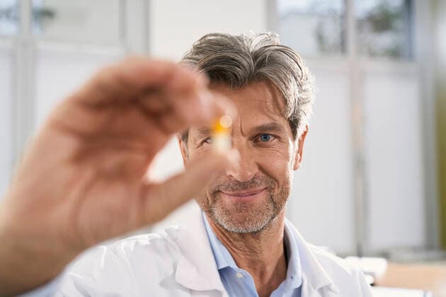 Portrait of doctor holding capsule in his medical practice model released Symbolfoto property released  PHDF00063