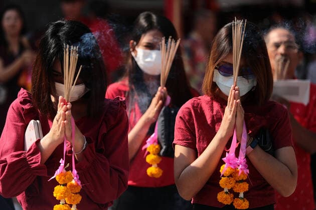 January 24, 2020, Bangkok, Thailand: Women pray while wearing a dust masks during the celebration at Leng Noei Yi Temple in Chinatown, Bangkok. The Lunar New Year, also known as Spring Festival in China marks the beginning of the Year of the Rat. The ethnic Chinese-Thai family pray for good fortune and wear masks for dust protection as the country struggles to contain worsening air pollution. Bangkok Thailand - ZUMAs197 20200124_zaa_s197_063 Copyright: xPatipatxJanthongx