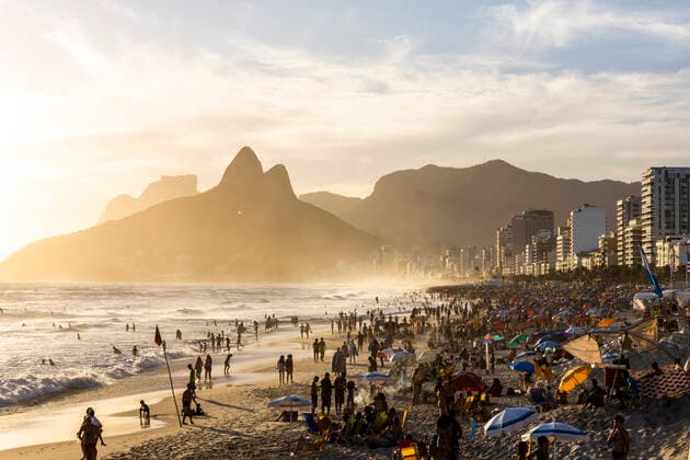 IMAGO Nature: Unsere Erde, Umweltprobleme, Überbevölkerung Beautiful sunset view to people enjoying the beach near big mountain Rio de Janeiro, RJ, Brazil CR_GNUJ200106-270131-01