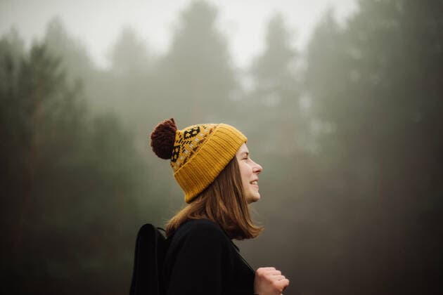 Thoughtful woman standing by forest in foggy weather CR_INCH200110-280600-01