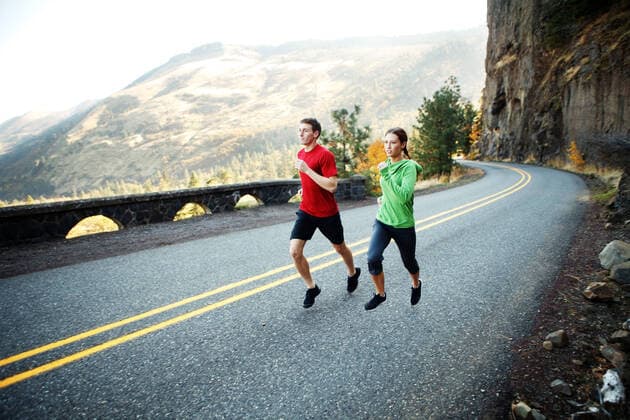 Two runners in their mid 20s running along scenic road in Rowena Rowena, OR, United States CR_ISKO200105A-258045-01