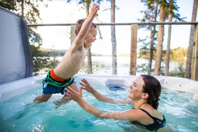 young boy jumping to mother in hot tub during vacation. Lac Le Jeune, BC, Canada CR_JDIP200102-245326-01