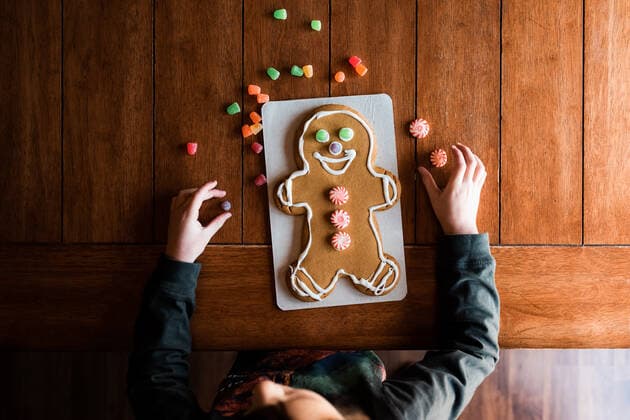 Small kid decorating a gingerbread man on the kitchen table Marshalltown, IA, United States CR_KAVO191211-258389-01
