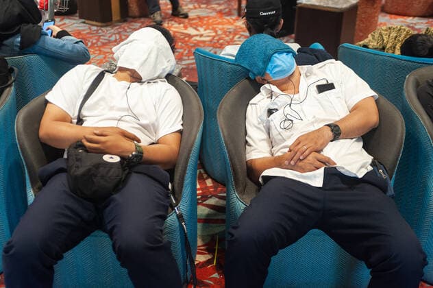 31 01 2020, Singapore, Republic of Singapore, Asia Two air travellers have covered their faces with cloths and are sleeping in armchairs in the arrivals area of Terminal 1 at Changi Airport One of them is also wearing a respiratory mask to protect himself against infection with the corona virus