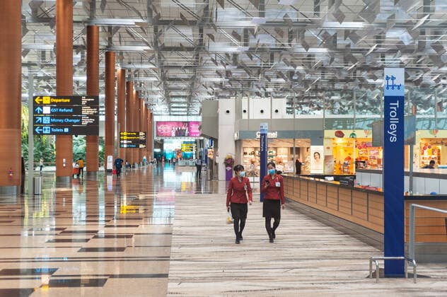 31 01 2020, Singapore, Republic of Singapore, Asia Two airport employees wear respirators while walking through the departure hall of Terminal 3 at Changi Airport