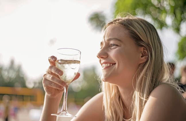 laughing young woman drinking wine