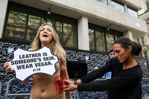February 14, 2020, London, UK, UK: London, UK. A half naked PETA (People for the Ethical Treatment of Animals) activist holds a sign LeatherÃ‚ Is Someone s Skin. Wear VeganÃ¢â‚¬â ¢ as her skin is ripped off during a protest at start of London Fashion Week against the use of animal products in the leather industry. London UK  - ZUMAl94_ 20200214_zaf_l94_034 Copyright: xDinendraxHariax