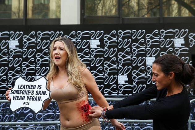 February 14, 2020, London, UK, UK: London, UK. A half naked PETA (People for the Ethical Treatment of Animals) activist holds a sign LeatherÃ‚ Is Someone s Skin. Wear VeganÃ¢â‚¬â ¢ as her skin is ripped off during a protest at start of London Fashion Week against the use of animal products in the leather industry. London UK  - ZUMAl94_ 20200214_zaf_l94_036 Copyright: xDinendraxHariax