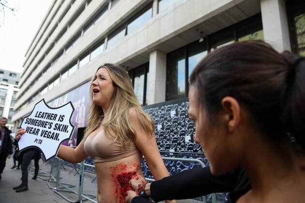 February 14, 2020, London, UK, UK: London, UK. A half naked PETA (People for the Ethical Treatment of Animals) activist holds a sign LeatherÃ‚ Is Someone s Skin. Wear VeganÃ¢â‚¬â ¢ as her skin is ripped off during a protest at start of London Fashion Week against the use of animal products in the leather industry. London UK  - ZUMAl94_ 20200214_zaf_l94_040 Copyright: xDinendraxHariax