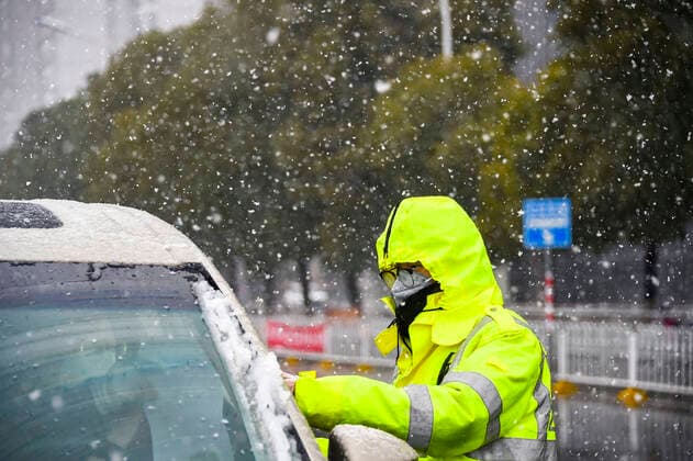 (200215) -- XIAOGAN, Feb. 15, 2020 -- Traffic police Wang Wenqi checks a car in Xiaogan, central China s Hubei Province, Feb. 15, 2020. Xiaogan witnessed a snowfall on Saturday as people around the city still fight in the battle against the novel coronavirus. ) CHINA-HUBEI-XIAOGAN-SNOW-NCP(CN) HuxHuhu 