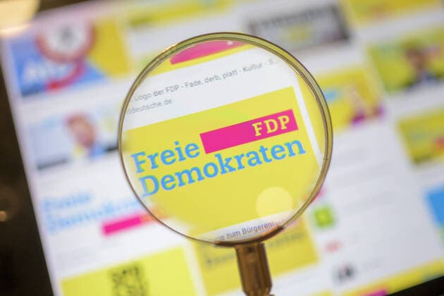 FDP logo, politics, symbol image, FDP party logo viewed through a magnifying glass