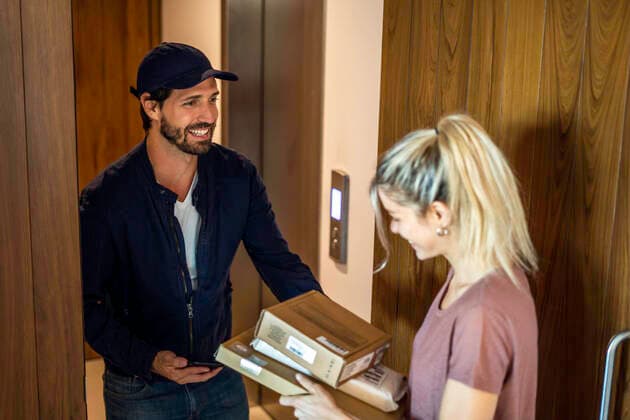 Young woman receiving parcels from delivery man Copyright: FrédéricxCirou B03587731