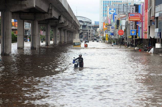 IMAGO Nature: Unsere Erde, Klimawandel, Überschwemmungen (200223) -- JAKARTA, Feb. 23, 2020 -- A man with his motorbike walks through flood water at Kelapa Gading in Jakarta, Indonesia, Feb. 23, 2020. Several areas in Jakarta were flooded on Sunday morning following heavy rains overnight. (Photo by Xinhua) INDONESIA-JAKARTA-FLOOD DasrilxRoszandi 