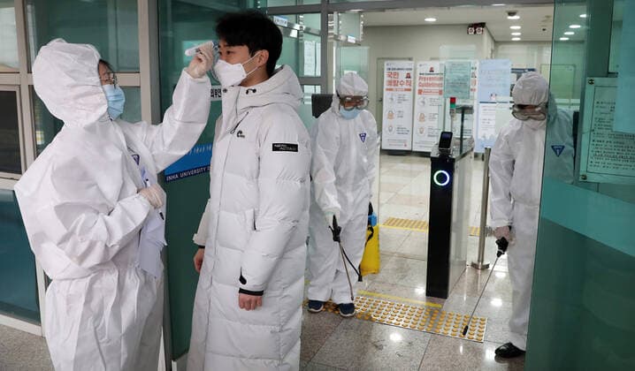 (200225) -- SEOUL, Feb. 25, 2020 -- A staff member checks a student s body temperature at the Inha University in Incheon, South Korea, Feb. 25, 2020. South Korea confirmed 144 more cases of the COVID-19 on Tuesday, raising the total number of infections to 977, and the death toll rose to 10. (NEWSIS Handout via Xinhua) SOUTH KOREA-COVID-19-INFECTIONS NiuxXisitongxunshe 