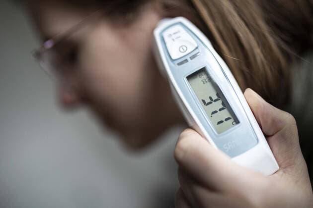 A woman measures fever in her ear in Berlin, 26 02 2020 The novel corona virus brings the symptom of suddenly severe fever Berlin Germany Copyright: xFlorianxGaertner photothek.netx
