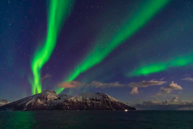A fine display of aurora in curtains across the north, October 19, 2019, observed from the upper Deck 9 of the ms Trollfjord on the southbound voyage north of Tromso along the Norwegian coast. Illumination is partly from the waning gibbous Moon. This is a 1-second exposure with the 15mm lens at f 2 and Sony a7III at ISO 6400. Copyright: xAlanxDyerx xVWPicsx ADY-2019-242