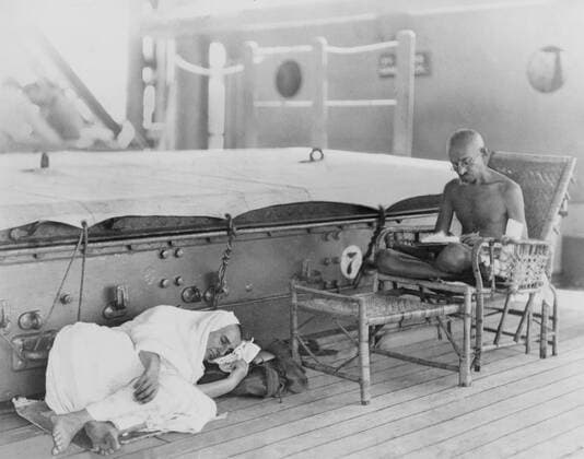 IMAGO ICONS: Mahatma Gandhi Mahatma Gandhi (1869-1948), leader of the Indian independence movement, on the S.S. Rajputna, enroute to the Round Table Conference in London. His disciple, Madeline Slade, renamed Mirabehn by Gandhi, lies on the nearby deck. 1931. Courtesy Everett Collection PUBLICATIONXNOTxINxCANxCHNxFRAxITAxJPNxNORxPOLxRUSxESPxUKxUSA Copyright: xCourtesyxEverettxCollectionx HISL013 EC001