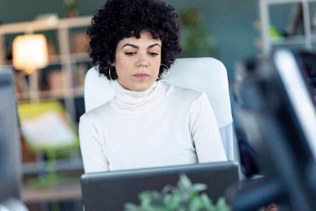 Female entrepreneur using laptop in an office model released Symbolfoto property released  JSRF00833