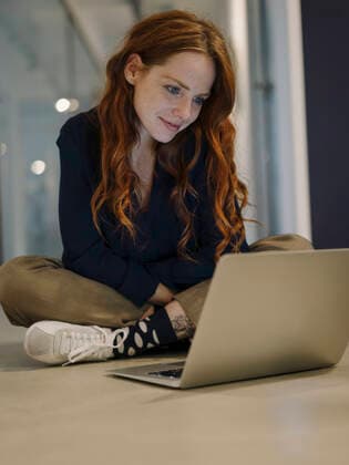 Redheaded woman using laptop on the floor model released Symbolfoto property released  KNSF07176