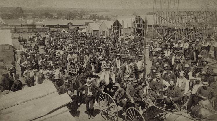 Crowd of men, most looking toward the photographer, in Guthrie, Oklahoma, four weeks after the 1889 Land Rush. It includes Native Americans is distinctive clothing. In the background are railroad cars, buildings, and construction sites (BSLOC_2018_1_117) For usage credit please use; PUBLICATIONXNOTxINxCANxCHNxFRAxITAxJPNxNORxPOLxRUSxESPxUKxUSA Copyright: xCourtesyxEverettxCollectionx HISL046 EC674