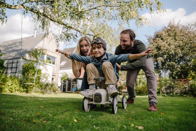 Boy sitting on toy car, pretending to fly, parents encourageing him model released Symbolfoto property released  KNSF07252