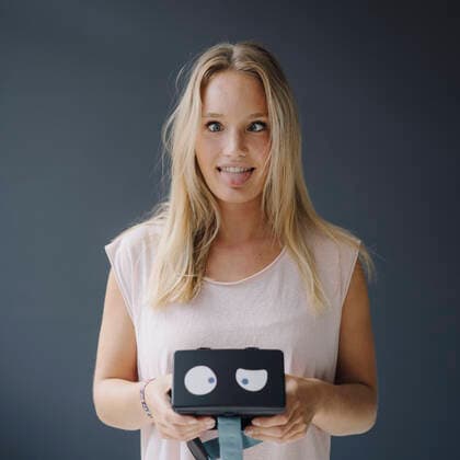 Young woman grimacing holding VR glasses with squinting eyes model released Symbolfoto property released  KNSF07399