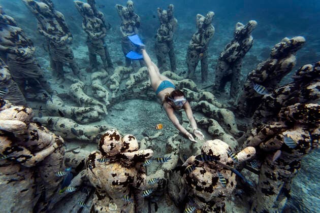Woman swimming near underwater sculpture made by Jason deCaires Taylor, Gili Meno island, Bali, Indonesia model released Symbolfoto  KNTF04341