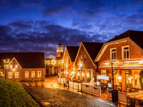 Germany, Lower Saxony, Landkreis Leer, Friesland, Ditzum, Houses illuminated for Christmas at dusk  LAF02456