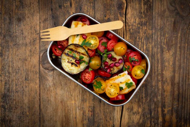 Lunch box with tomato salad with grilled vegetables and halloumi cheese, pomegranate seeds, sumac, black sesame and parsley  LVF08552