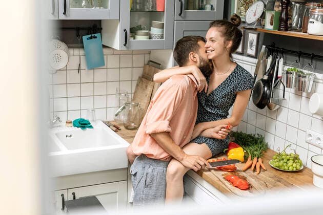 Affectionate couple in kitchen, preparing food model released Symbolfoto property released  PESF01785