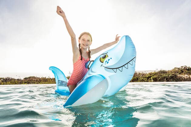 Portrait of happygirl in swimming pool with inflatable shark pool toy model released Symbolfoto property released  SDAHF00253