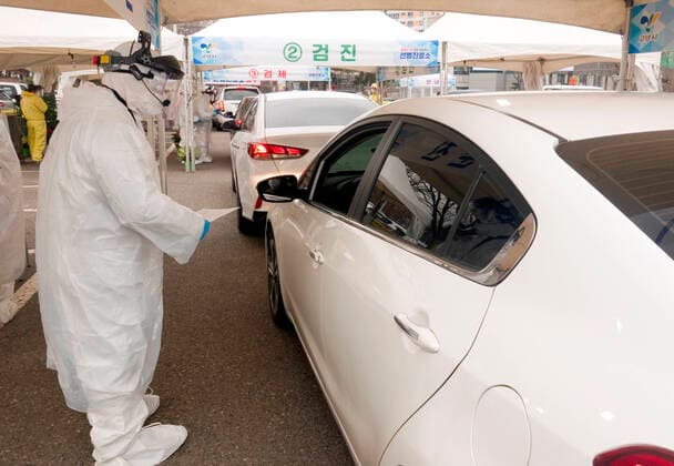 Drive-thru clinic testing of the COVID-19, Feb 28, 2020 : People in their cars arrive at a drive-thru clinic testing of the COVID-19 in Goyang, north of Seoul, South Korea. South Korea s local governments have introduced testing facilities where medical staff take samples from people in cars who have suspected symptoms of COVID-19. Drivers do not have to get out of their cars and they open a window to be checked for fever or have samples taken by medical staff in protective suits. Health authorities said the entire process takes about 10 minutes. South Korea reported 571 new cases of the coronavirus on Friday to bring the total number of infections to 2,337 as the country worked actively to counter the spreading virus with extensive testing, local media reported.  (123340522)