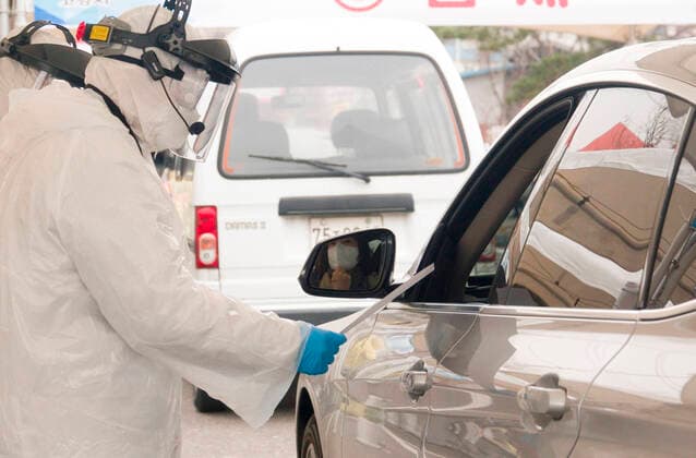 Drive-thru clinic testing of the COVID-19, Feb 28, 2020 : People in their cars arrive at a drive-thru clinic testing of the COVID-19 in Goyang, north of Seoul, South Korea. South Korea s local governments have introduced testing facilities where medical staff take samples from people in cars who have suspected symptoms of COVID-19. Drivers do not have to get out of their cars and they open a window to be checked for fever or have samples taken by medical staff in protective suits. Health authorities said the entire process takes about 10 minutes. South Korea reported 571 new cases of the coronavirus on Friday to bring the total number of infections to 2,337 as the country worked actively to counter the spreading virus with extensive testing, local media reported.  (123340671)