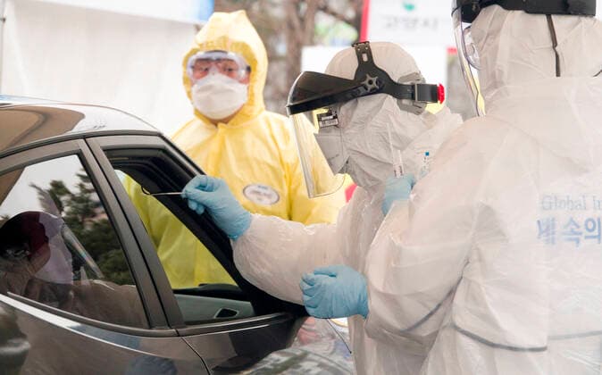 Drive-thru clinic testing of the COVID-19, Feb 28, 2020 : Medical staff get samples at a drive-thru clinic testing of the COVID-19 in Goyang, north of Seoul, South Korea. South Korea s local governments have introduced testing facilities where medical staff take samples from people in cars who have suspected symptoms of COVID-19. Drivers do not have to get out of their cars and they open a window to be checked for fever or have samples taken by medical staff in protective suits. Health authorities said the entire process takes about 10 minutes. South Korea reported 571 new cases of the coronavirus on Friday to bring the total number of infections to 2,337 as the country worked actively to counter the spreading virus with extensive testing, local media reported.  (123342489)