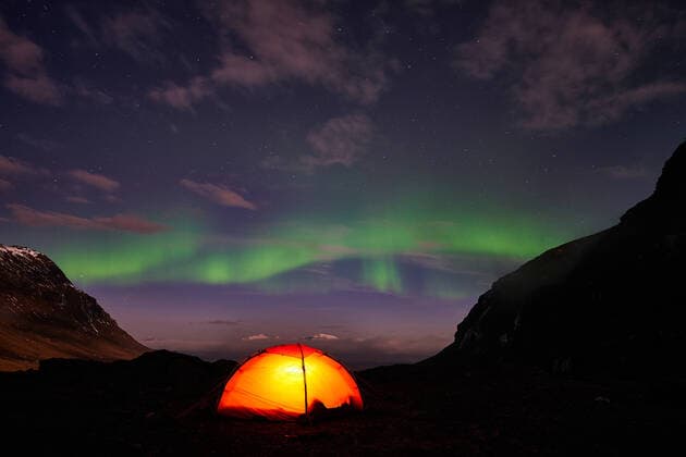 Northern lights Auroa borealis above illuminated tent, Norrbotten, Lapland, Sweden, October 2014 McPGUN McPGUN