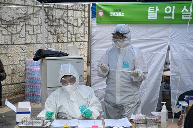 Health workers in biohazard collect samples from patients at a drive-thru coronavirus testing center at Seoul Metropolitan Eunpyeong Hospital on March 4, 2020  SEO2020030447 THOMASxMARESCA