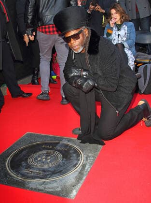 March 6, 2020, London, United Kingdom: Jazzie B, founder and leading light of the Soul II Soul collective Kneels next to a stone during the Music Walk Of Fame Soul II Soul stone unveiling, the fourth stone to be placed on Camden High Street in London. London United Kingdom - ZUMAs197 20200306_zaa_s197_165 Copyright: xKeithxMayhewx