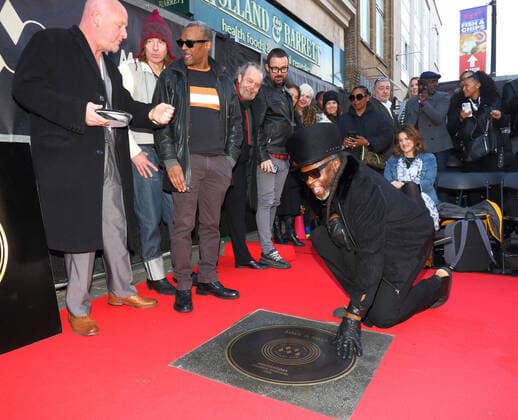 Entertainment Bilder des Tages March 6, 2020, London, United Kingdom: Jazzie B, founder and leading light of the Soul II Soul collective Kneels next to a stone during the Music Walk Of Fame Soul II Soul stone unveiling, the fourth stone to be placed on Camden High Street in London. London United Kingdom - ZUMAs197 20200306_zaa_s197_166 Copyright: xKeithxMayhewx