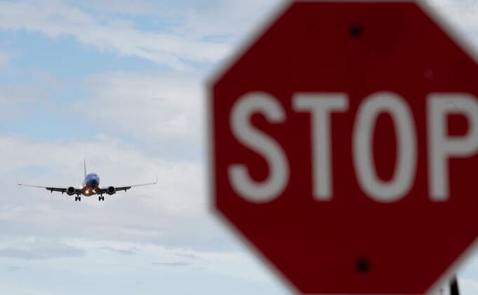(200312) -- WASHINGTON D.C., March 12, 2020 -- Photo taken on March 10, 2020 shows a stop sign and a plane approaching to land at Ronald Reagan Washington National Airport in Arlington, Virginia, the United States. U.S. President Donald Trump said on Wednesday night the country will suspend all travel from European countries except Britain for 30 days in a bid to fight the ongoing coronavirus outbreak. ) U.S.-NOVEL CORONAVIRUS-OUTBREAK-TRAVEL SUSPENSION LiuxJie 