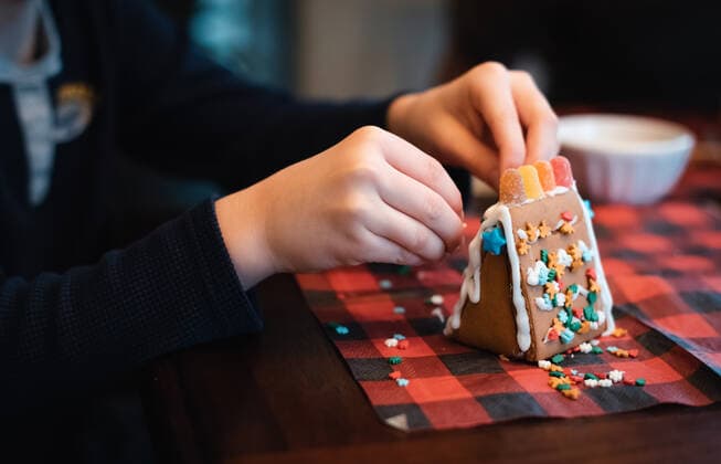 Close up of child s hands putting candies on a gingerbread house. Kingston, ON, Canada ,model released, Symbolfoto CR_DOHO200116C-281185-01