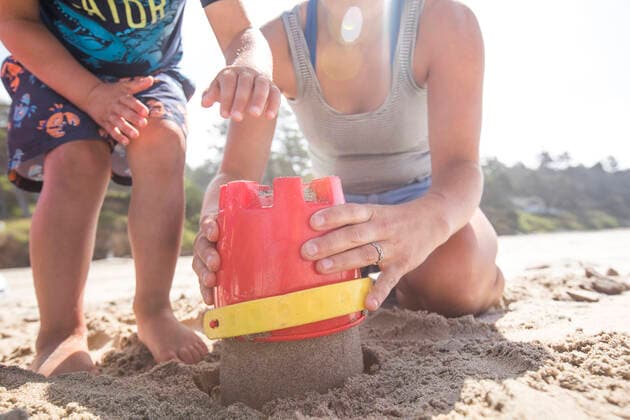 Low angle of mother and son building sand castle. Manzanita, OR, United States ,model released, Symbolfoto CR_JDIP200116A-282606-01